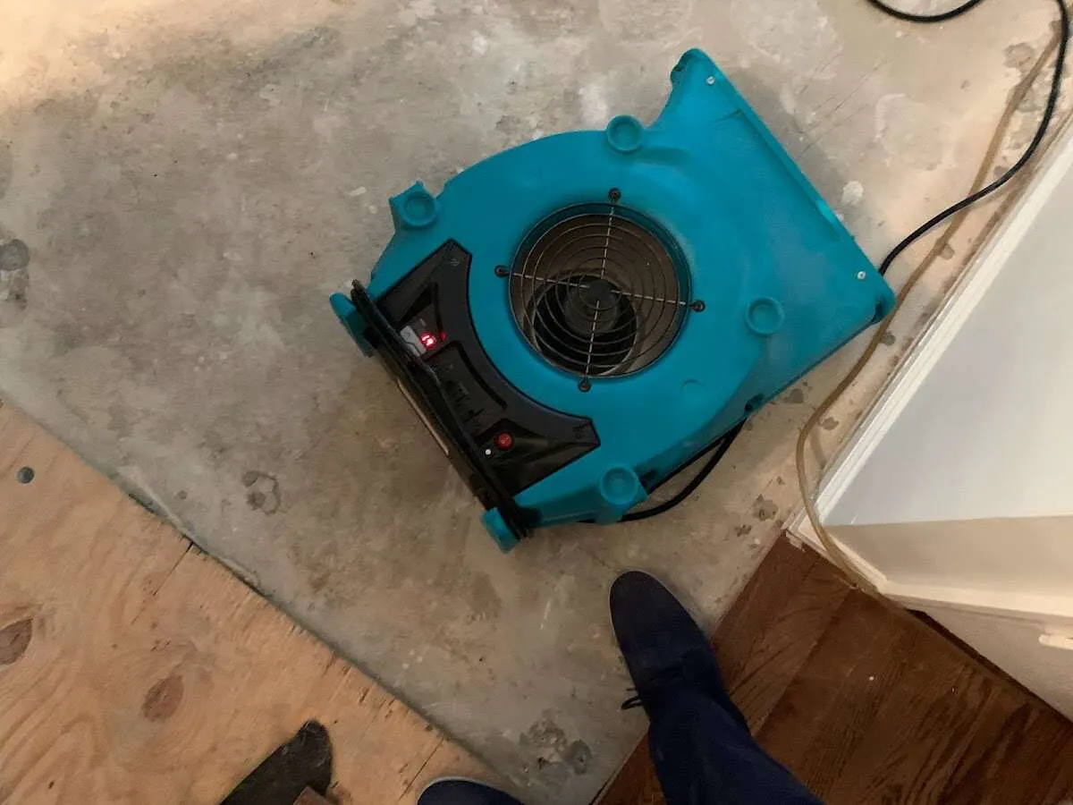 Air mover drying subfloor during Commercial Water Damage Restoration in Shasta Lake